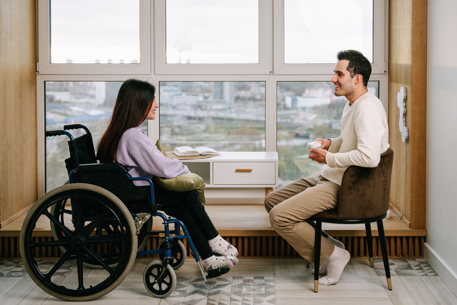 Two adults having a relaxed conversation in an accessible indoor community setting